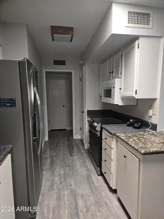 a kitchen with stainless steel appliances granite countertop a refrigerator a stove and a sink