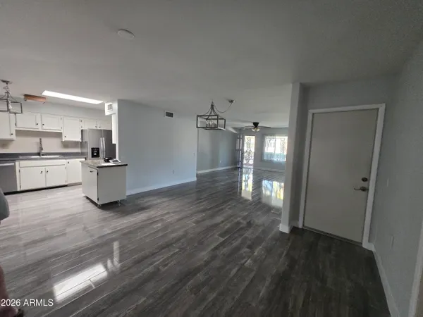 a kitchen with a refrigerator and wooden floor