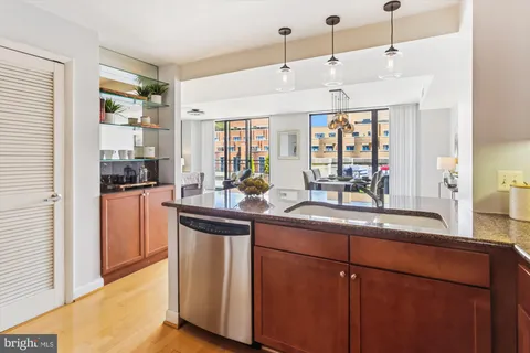 a kitchen with stainless steel appliances granite countertop a sink a stove cabinets counter space and a window