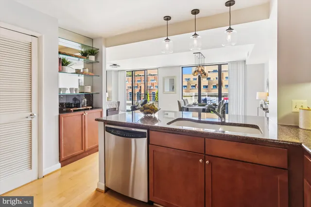 a kitchen with stainless steel appliances granite countertop a sink a stove cabinets counter space and a window