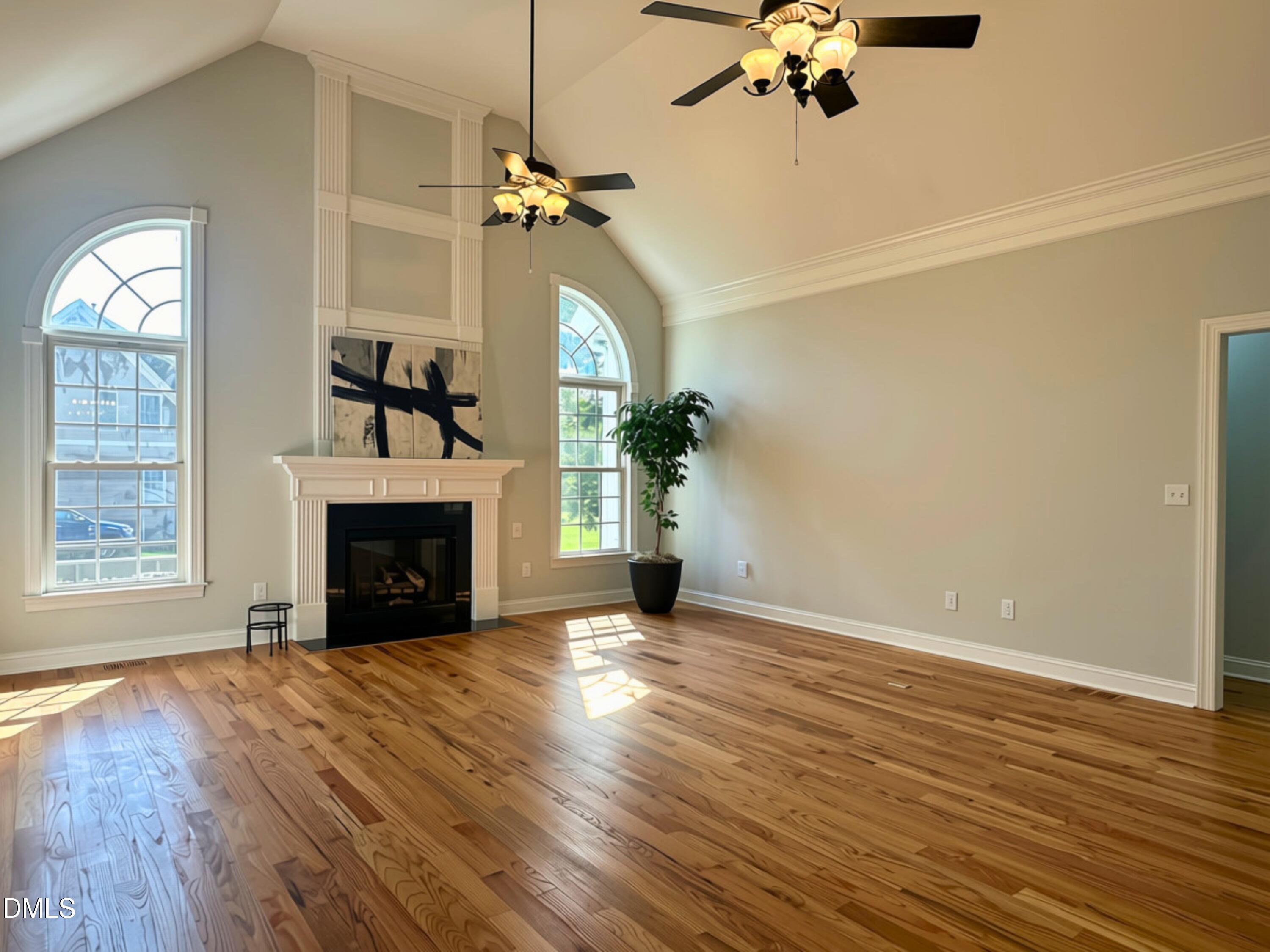3100 Donlin Drive Wake Forest, NC 27587 - Photo 8 of 67 Vaulted ceiling, hardwood flooring, fireplace with mantel, arched windows, and ceiling fans