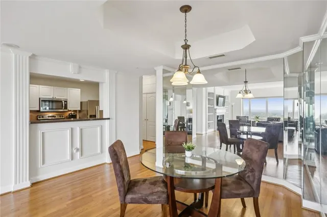 a view of a dining room and livingroom with furniture wooden floor a chandelier