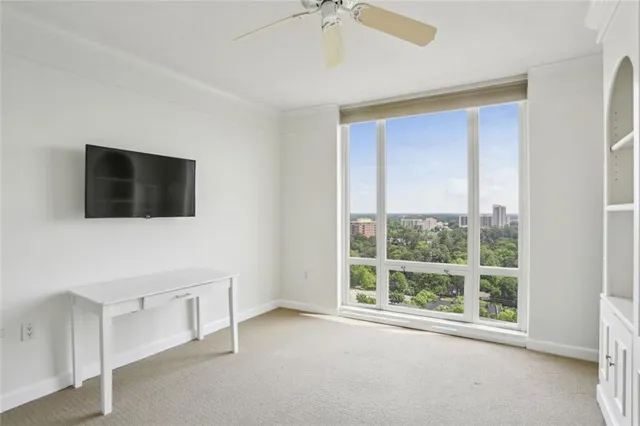a view of an empty room with a window and a flat screen tv