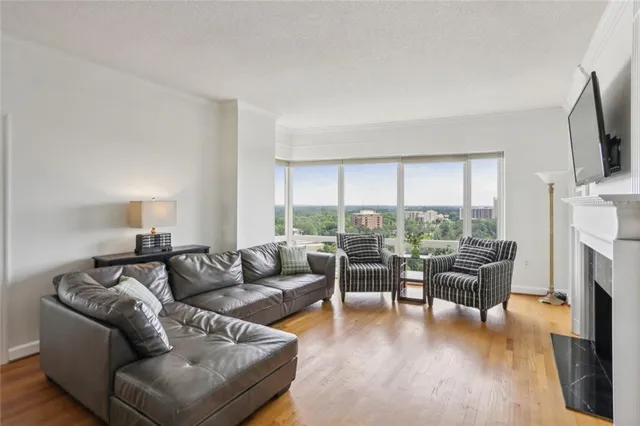 a living room with fireplace furniture and a large window