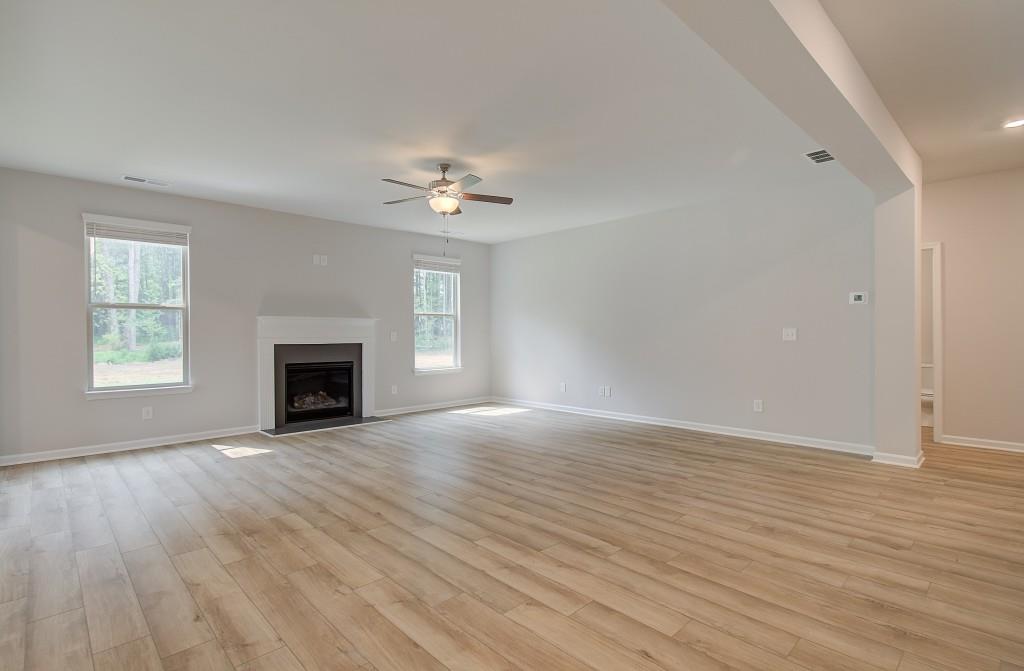 624 Sidney Court Stockbridge, GA 30281 - Photo 12 of 29 an empty room with windows fireplace and wooden floor