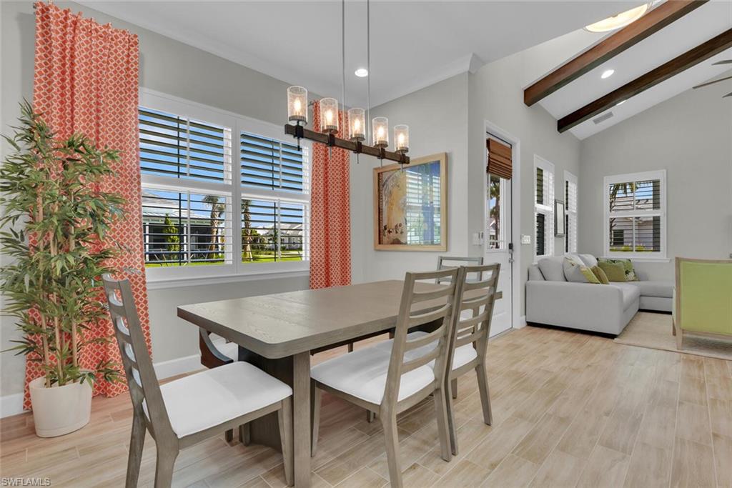 7110 Cayo Coco Lane Naples, FL 34113 - Photo 8 of 45 Dining room with lofted ceiling with beams, a chandelier, and light hardwood / wood-style floors