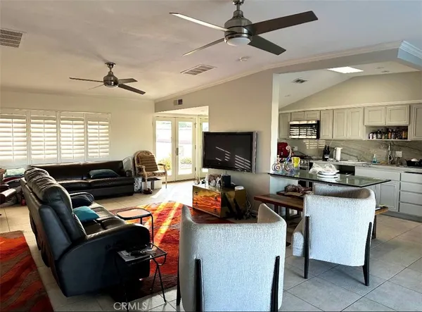 a work room with furniture a flat screen tv and a window