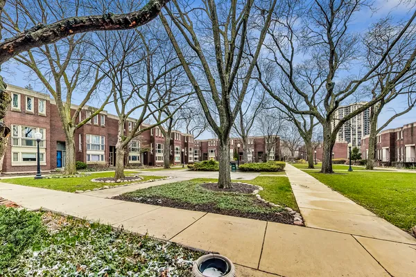 a view of residential houses with yard and trees