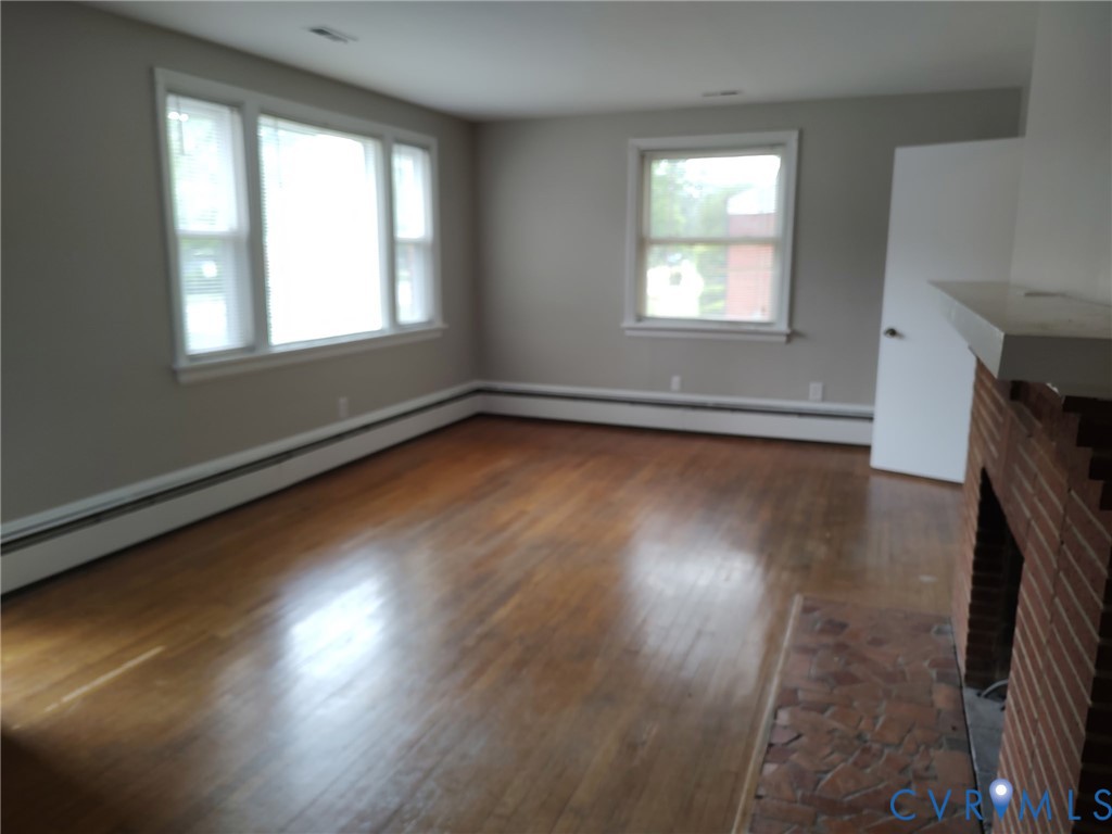 5310 Raleigh Road Henrico, VA 23231 - Photo 4 of 15 an empty room with wooden floor and windows