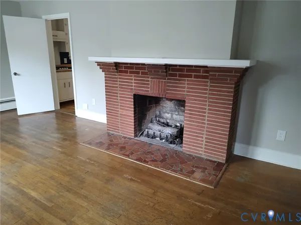 an empty room with wooden floor and fireplace