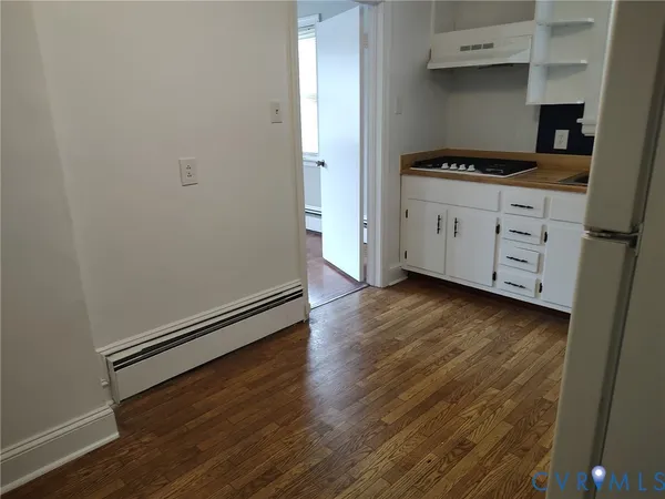 a kitchen with granite countertop a stove and a wooden floors
