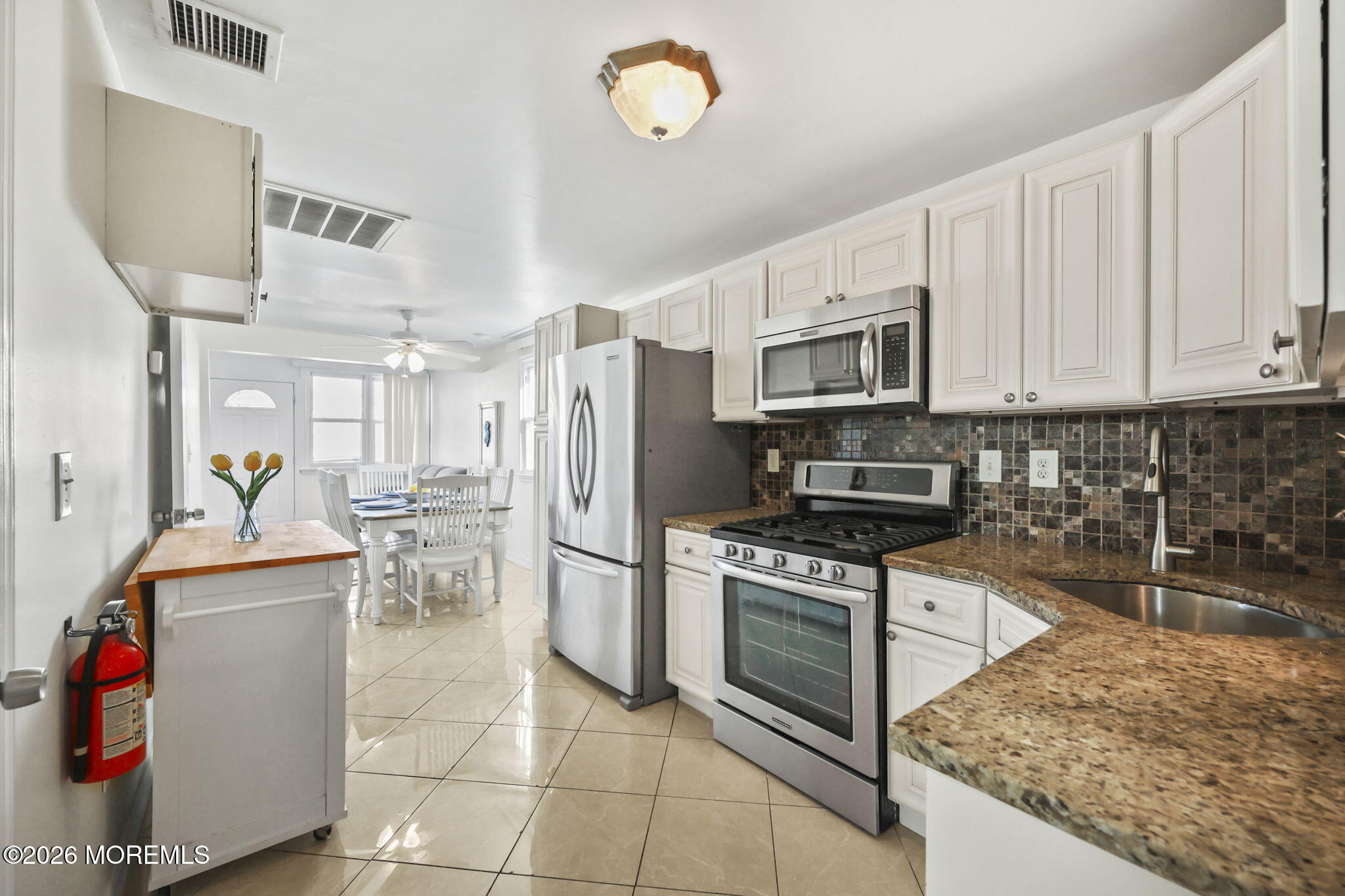 211 Ocean Avenue Point Pleasant Beach, NJ 08742 - Photo 20 of 60 a kitchen with granite countertop a refrigerator a stove a microwave and island