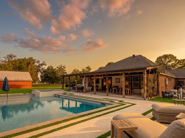 1114 Wagon Road Simonton, TX 77485 - Photo 10 of 48 Experience outdoor living with this beautiful backyard oasis, featuring a sparkling pool, spacious patio, and sunset views perfect for relaxation and entertaining.