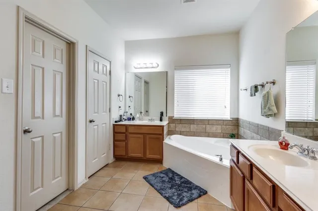 a bathroom with a tub sink and mirror