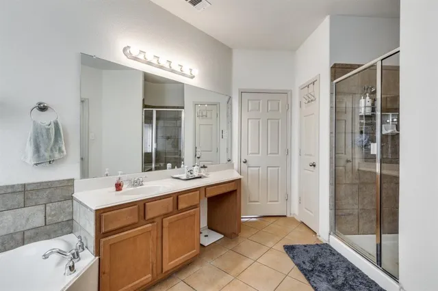 a spacious bathroom with a shower sink and mirror