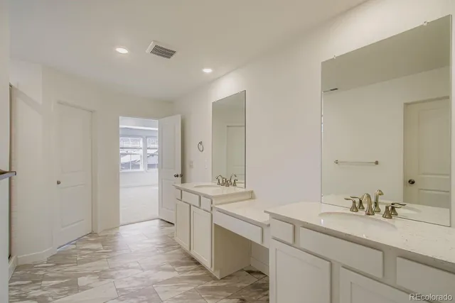 a bathroom with a sink double vanity granite tub shower and a mirror