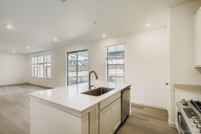 a kitchen with kitchen island a sink and a stove with wooden floor