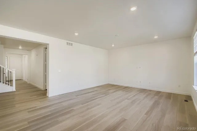 a view of an empty room with wooden floor