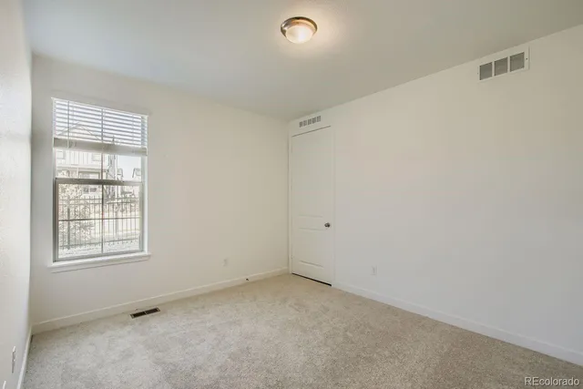 an empty room with windows and closet