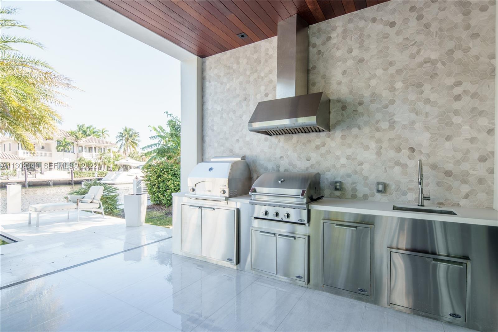 128 Fiesta Way Fort Lauderdale, FL 33301 - Photo 14 of 60 a kitchen with a stove top oven and cabinets