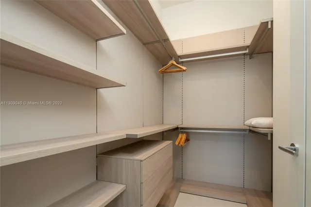 a bedroom with a large bed couch and windows