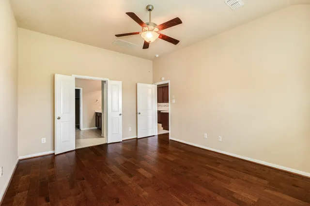 a view of an empty room with wooden floor