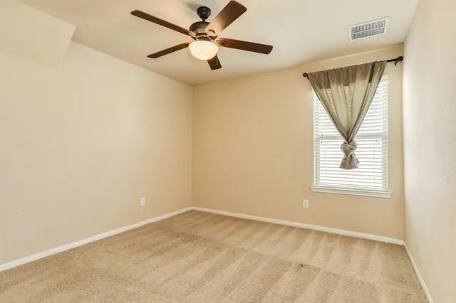 a view of empty room with ceiling fan