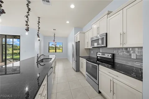 a kitchen with stainless steel appliances granite countertop a refrigerator and a stove top oven