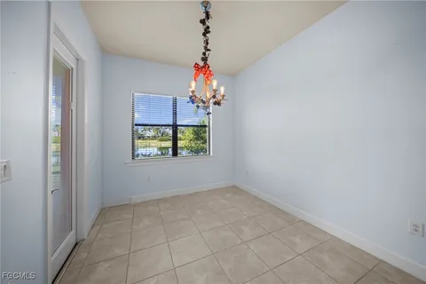 an empty room with windows and chandelier