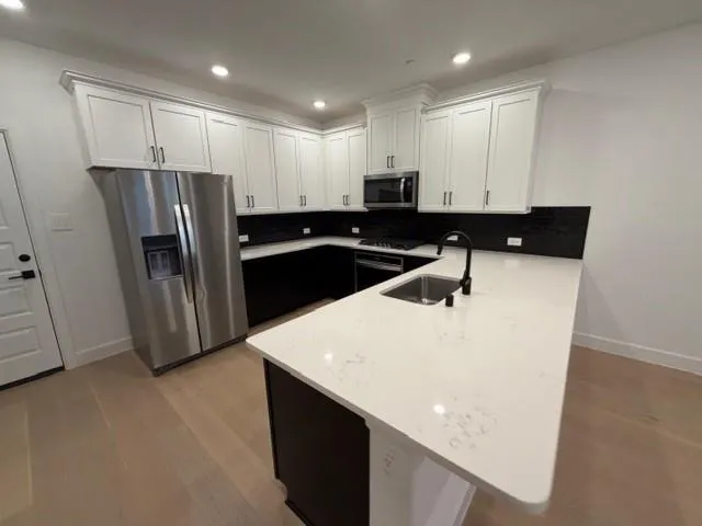 a kitchen with stainless steel appliances a refrigerator a sink a stove a microwave and island