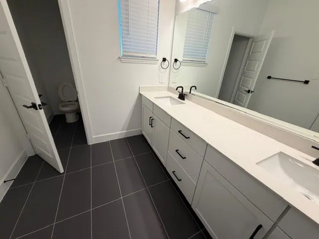 a bathroom with a double vanity sink and mirror