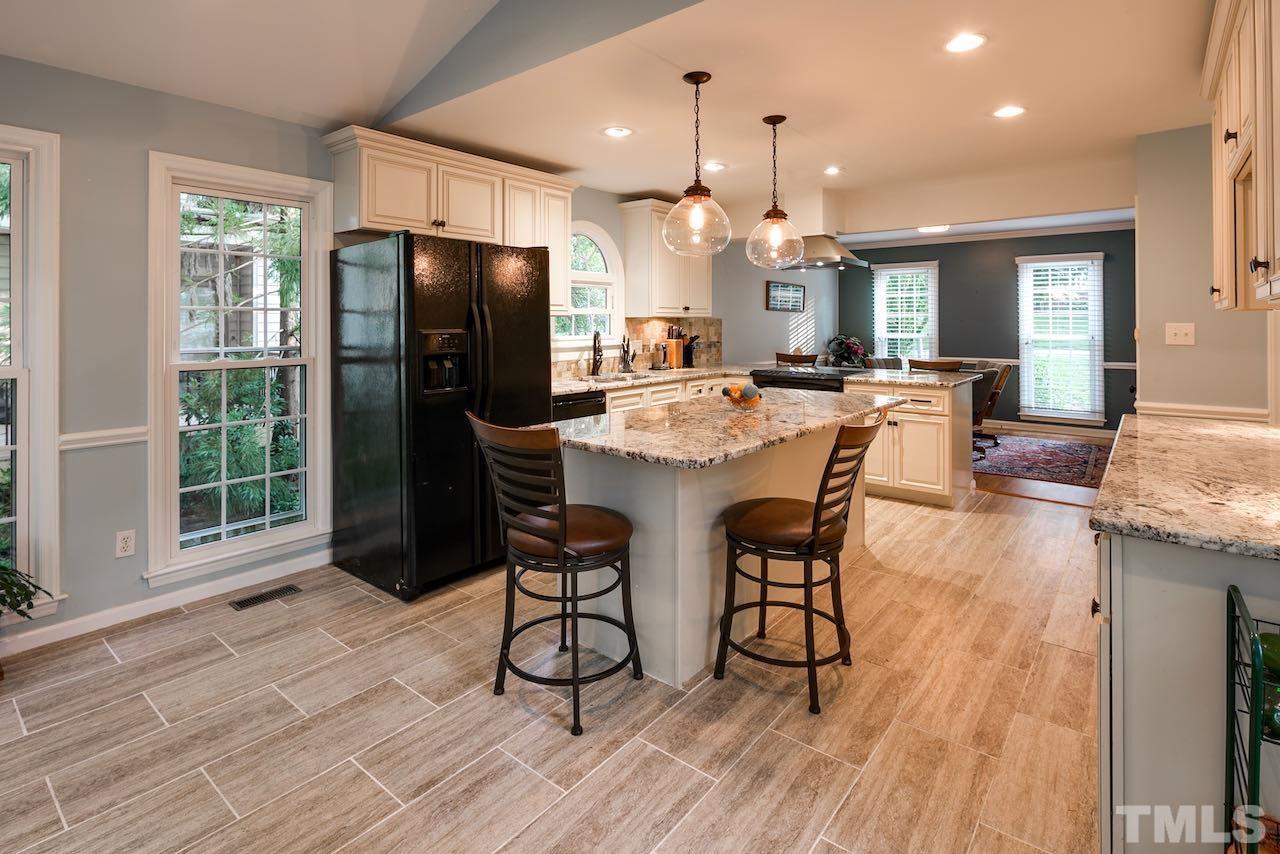 4 Cedar Hill Drive Durham, NC 27713 - Photo 5 of 49 a dining room with stainless steel appliances kitchen island granite countertop a table chairs and a refrigerator