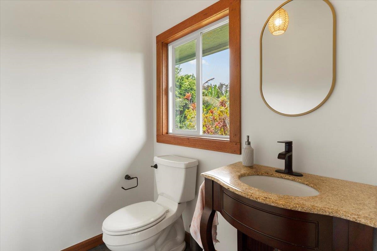 60 Koolau Road Haiku, HI 96708 - Photo 18 of 47 a bathroom with a granite countertop toilet a sink and a mirror