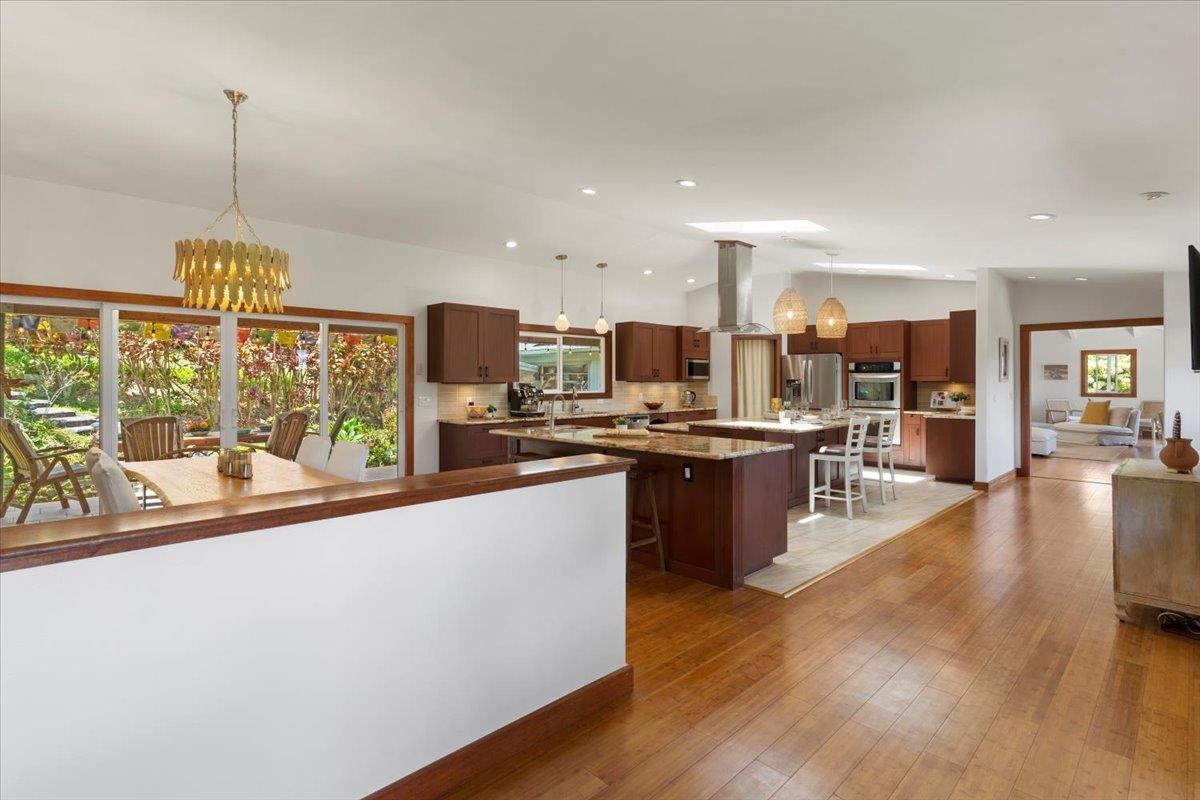 60 Koolau Road Haiku, HI 96708 - Photo 6 of 47 a open kitchen with stainless steel appliances granite countertop a refrigerator a stove top oven a sink dishwasher and wooden floor