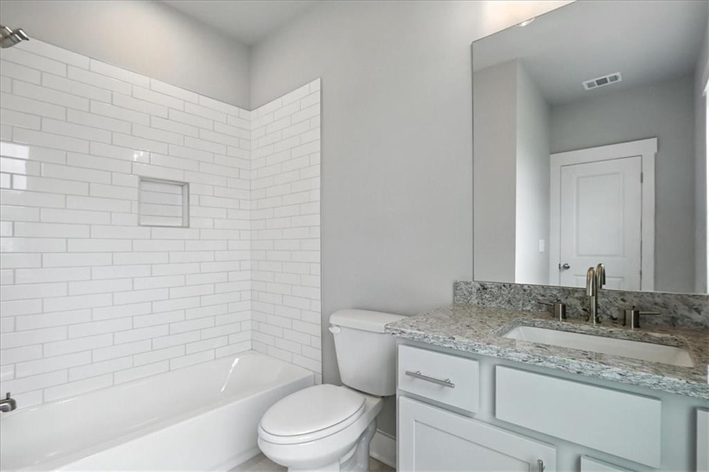 95 Old Town Road Dacula, GA 30019 - Photo 51 of 74 a bathroom with a granite countertop toilet a sink and bathtub