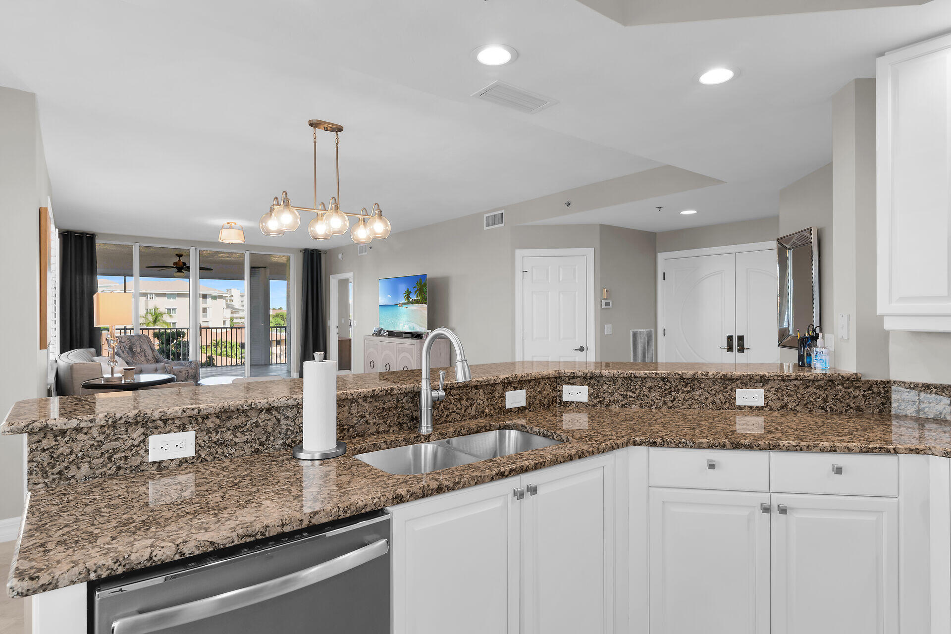 1111 Swallow Avenue, Unit 1401 Marco Island, FL 34145 - Photo 18 of 36 a large kitchen with granite countertop a counter space a sink and stainless steel appliances