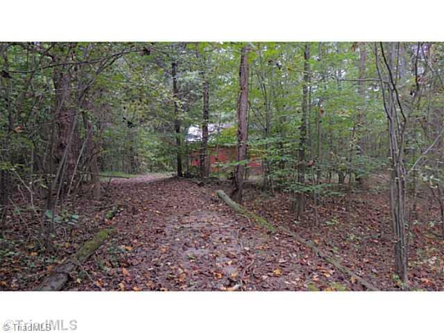 7410 Styers Ferry Road Clemmons, NC 27012 - Photo 8 of 16 Stable/Barn. Trail meanders through wooded boundary of the property. This section shows the approach to the barn.