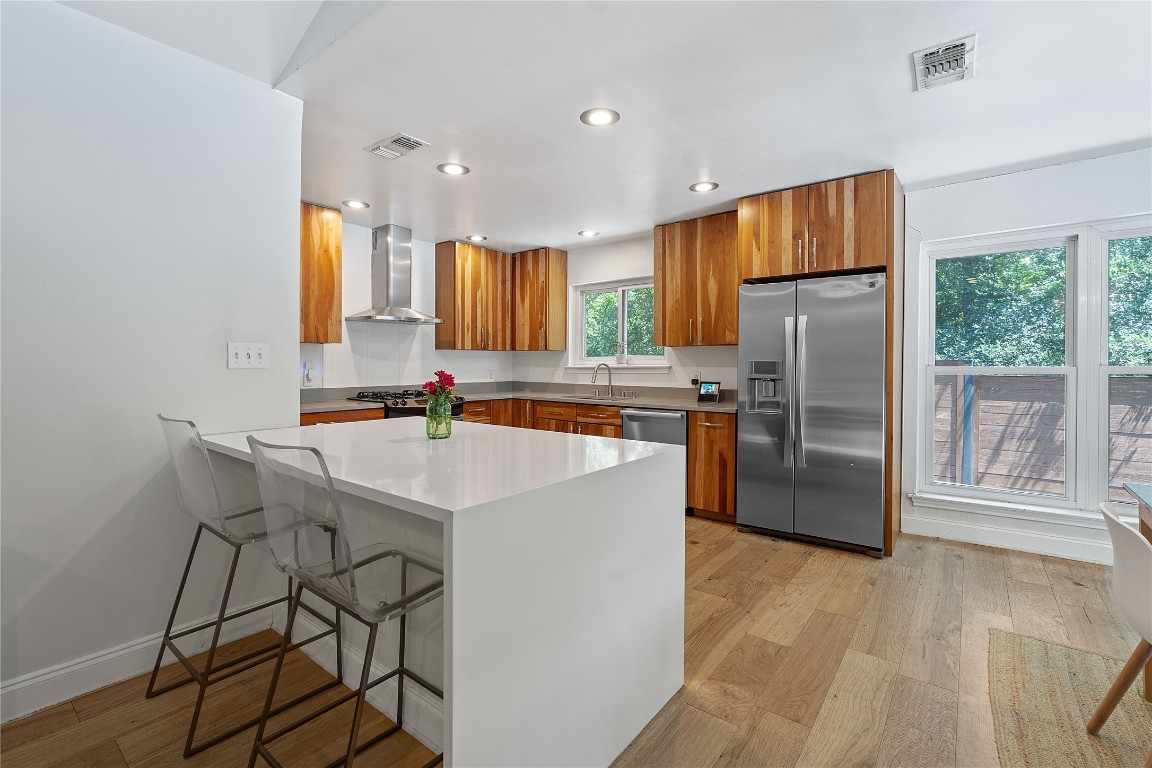 1407 Spring Garden Road Austin, TX 78746 - Photo 11 of 28 a kitchen with stainless steel appliances a refrigerator a stove a sink cabinets and a dining table