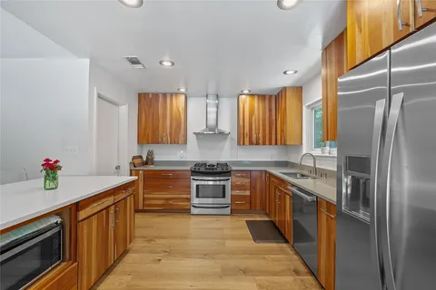 a kitchen with stainless steel appliances granite countertop a sink stove and refrigerator