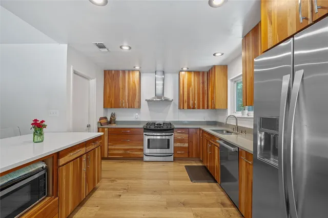 a kitchen with stainless steel appliances granite countertop a sink stove and refrigerator