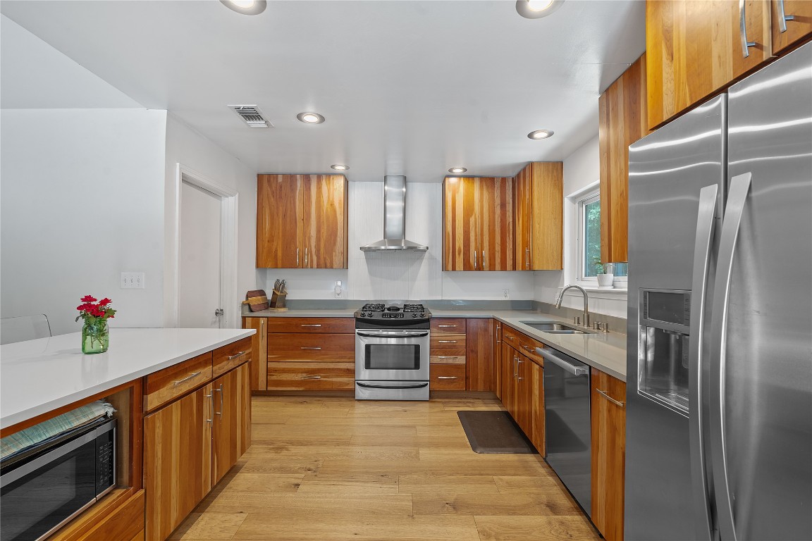 1407 Spring Garden Road Austin, TX 78746 - Photo 12 of 28 a kitchen with stainless steel appliances granite countertop a sink stove and refrigerator