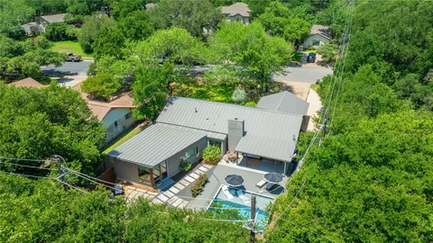an aerial view of a house with swimming pool and garden
