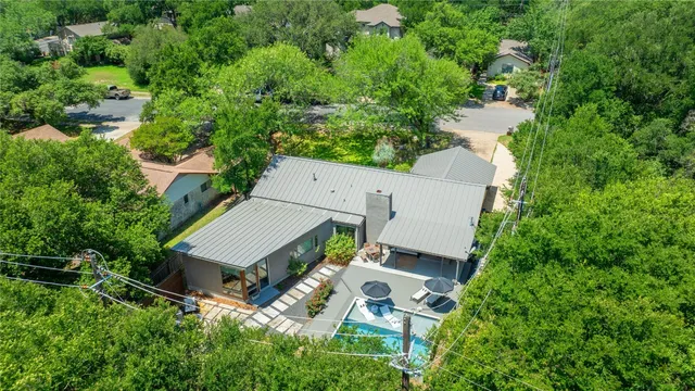 an aerial view of a house with swimming pool and garden