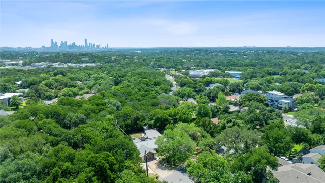 an aerial view of residential house with outdoor space and trees all around