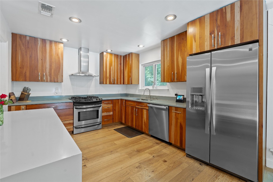 1407 Spring Garden Road Austin, TX 78746 - Photo 3 of 28 a kitchen with stainless steel appliances granite countertop a refrigerator sink and stove