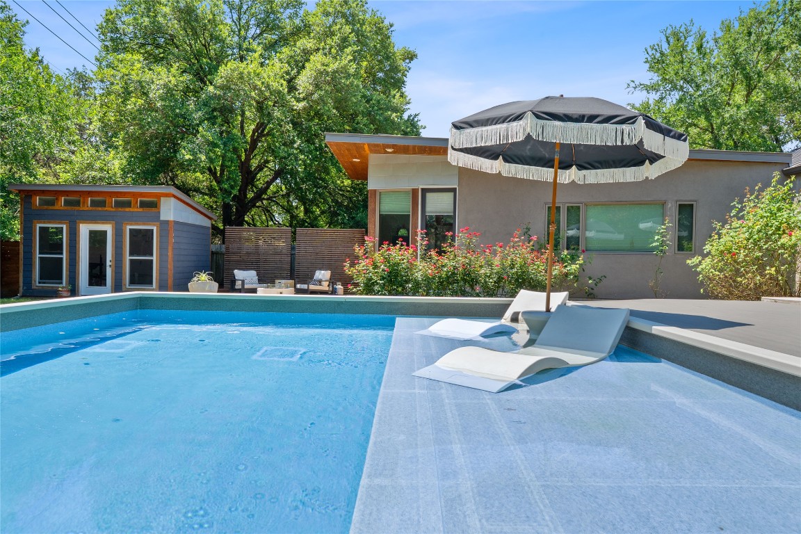 1407 Spring Garden Road Austin, TX 78746 - Photo 6 of 28 a view of a house with pool and chairs under an umbrella
