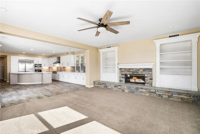 a large kitchen with granite countertop a large counter top stainless steel appliances and cabinets