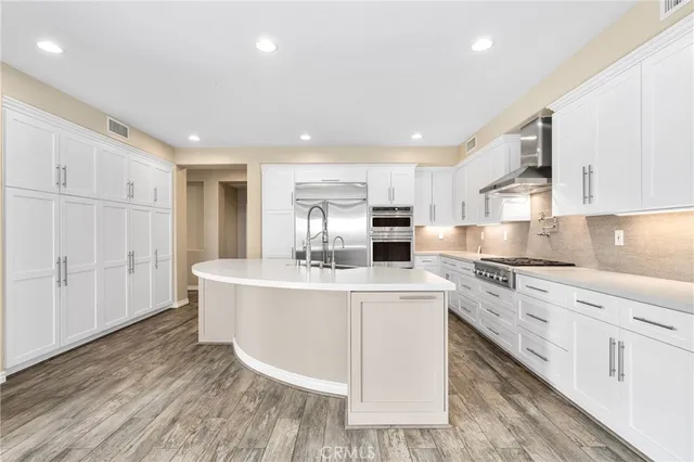 a kitchen with stainless steel appliances granite countertop a sink a stove and a refrigerator