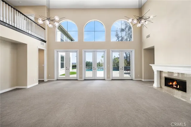a view of an empty room with windows and fireplace