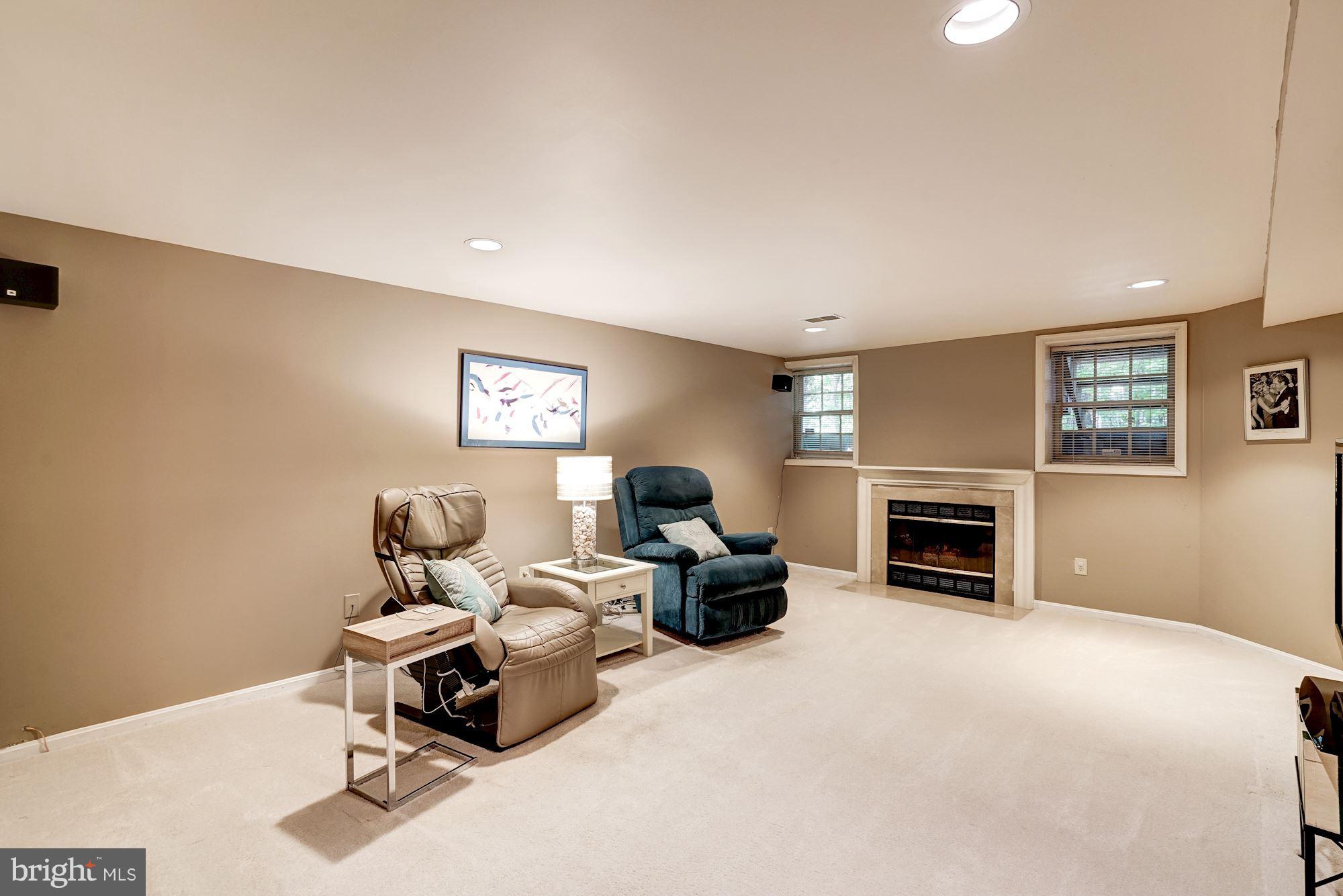 11406 Hollow Timber Way Reston, VA 20194 - Photo 20 of 30 a living room with furniture a fireplace and a flat screen tv
